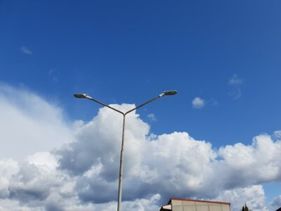 gatubelysning och vita moln på blå himmel